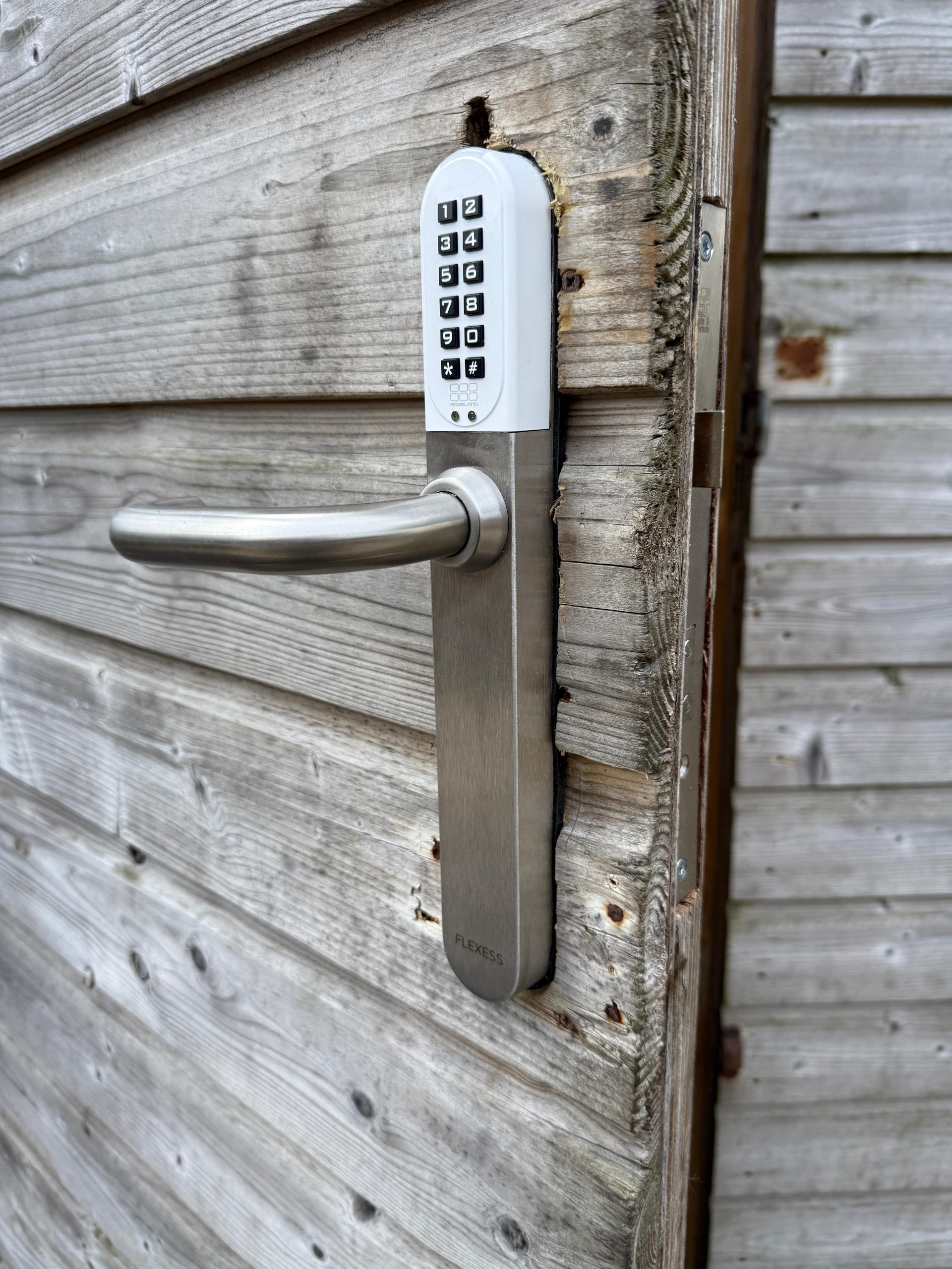 Codeslot met deurkruk op een houten poort