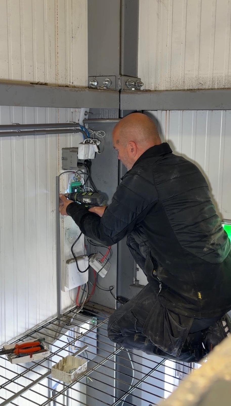Monteur werkt aan de bekabeling en besturing bij een bedrijf